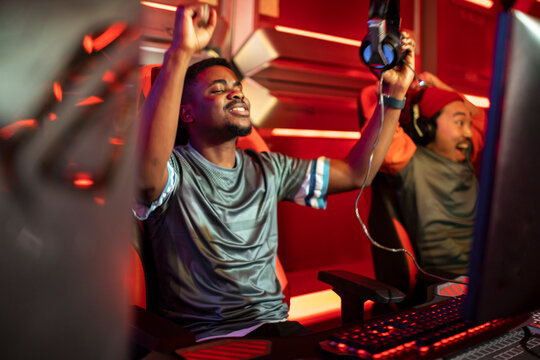 Two gamers celebrating esports team victory in gaming arena