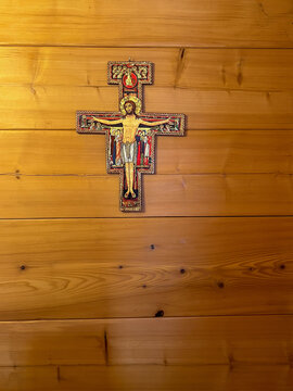 St. Damian's cross hanging on the wall of a fir log house.