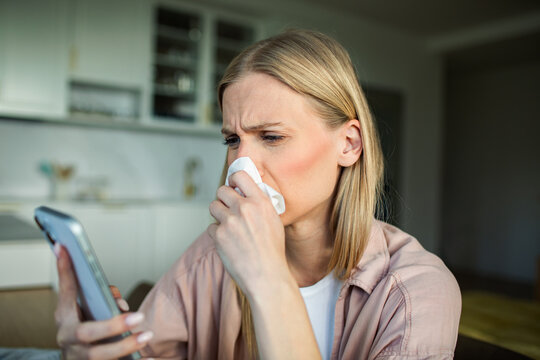 Sick woman using smartphone at home