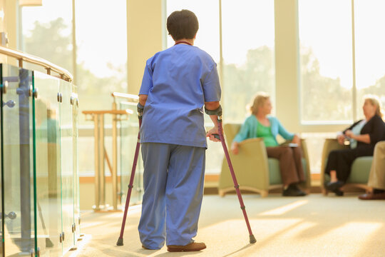 Nurse with Cerebral Palsy walking down the hallway of a clinic with her canes