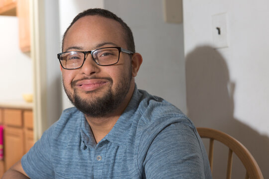 Portrait of happy African American man with Down Syndrome at home