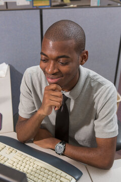 African American man with Autism working on computer in an office