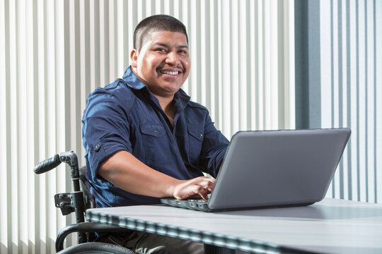 Hispanic man with Spinal Cord Injury working in an office