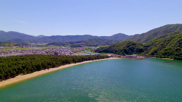 気比の松原（福井県敦賀市）の美しい入り江と松林、山々の風景、ゆっくり前進・左旋回するドローン空撮 / Beautiful Kehi no Matsubara cove, pine forest and mountains in Tsuruga, Fukui, slow forward and left pan drone aerial
