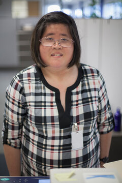 Asian woman with a Learning Disability working at a copy machine