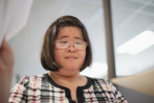 Asian woman with a Learning Disability working at a copy machine