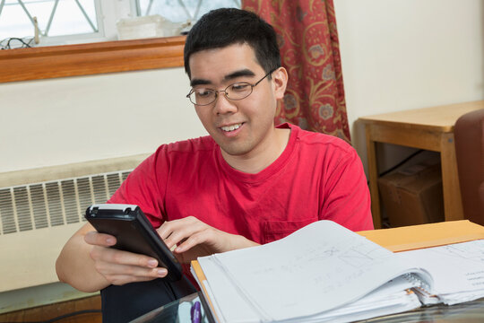 Happy Asian man with Autism using a phone