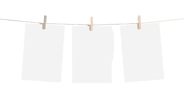 Three blank sheets hanging on a clothesline with clips