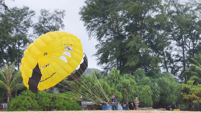 Careful preparation of extreme vacation activities begins as person checks lines. This exciting extreme vacation activities setup guarantees safe parachute flight above tropical trees.
