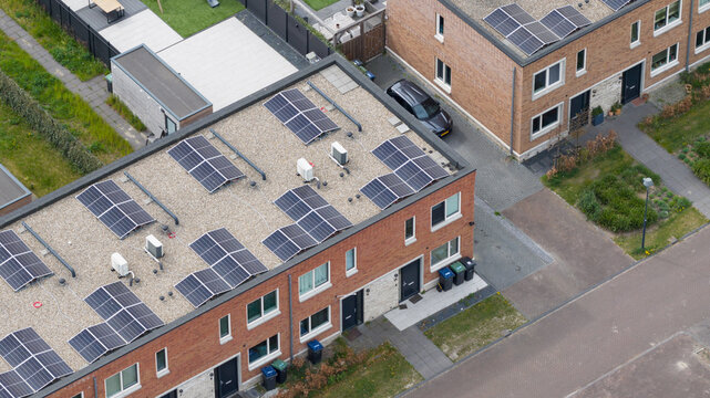 Aerial view of modern brick houses with solar panels on flat gravel roofs in the Nobelhorst neighborhood Almere, Flevoland, Netherlands.