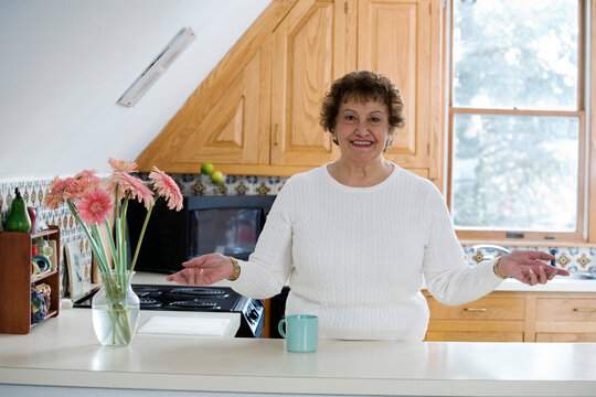 Portrait of a cheerful woman standing in a kitchen