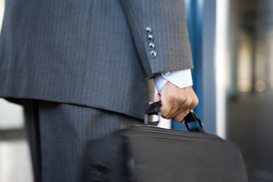 Close up of a young business man holding a briefcase