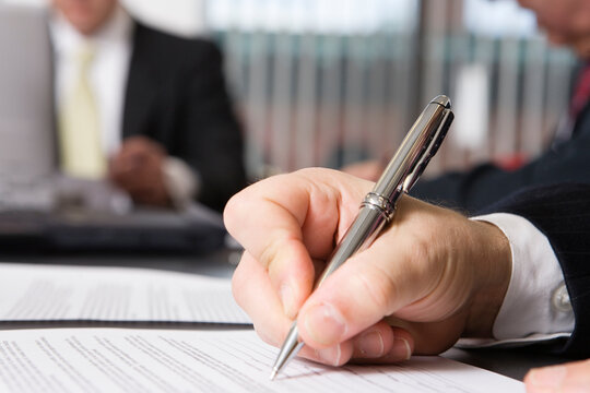 Close up of hand writing on a document