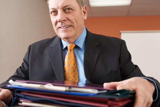 View of a businessman sitting with files in an office