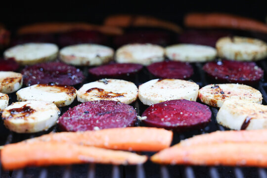 Farm fresh garden vegetables cooking on a pellet grill smoker for a vegetarian dinner. The healthy food is colorful and packed with vitamins and garden nutrients. Delicious!