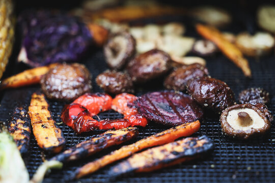 Farm fresh garden vegetables cooking on a pellet grill smoker for a vegetarian dinner. The healthy food is colorful and packed with vitamins and garden nutrients. Delicious!