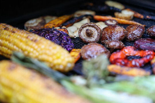 Farm fresh garden vegetables cooking on a pellet grill smoker for a vegetarian dinner. The healthy food is colorful and packed with vitamins and garden nutrients. Delicious!