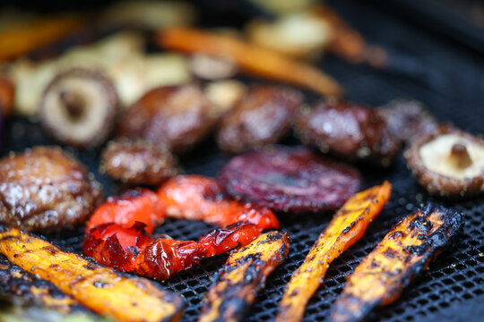 Farm fresh garden vegetables cooking on a pellet grill smoker for a vegetarian dinner. The healthy food is colorful and packed with vitamins and garden nutrients. Delicious!