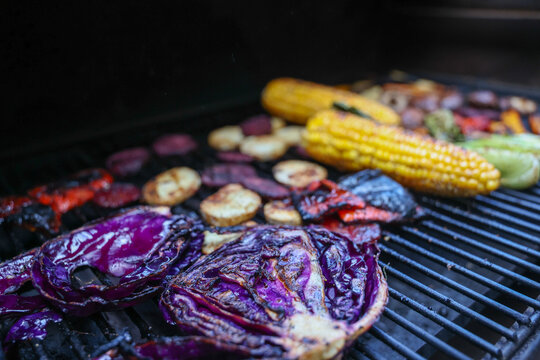 Farm fresh garden vegetables cooking on a pellet grill smoker for a vegetarian dinner. The healthy food is colorful and packed with vitamins and garden nutrients. Delicious!