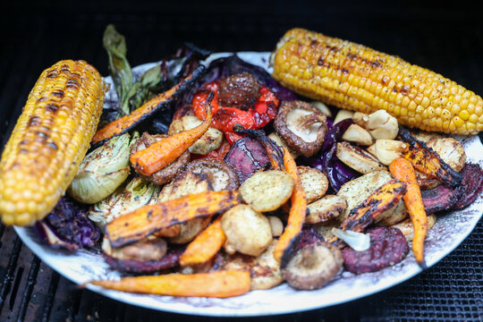 Farm fresh garden vegetables cooking on a pellet grill smoker for a vegetarian dinner. The healthy food is colorful and packed with vitamins and garden nutrients. Delicious!