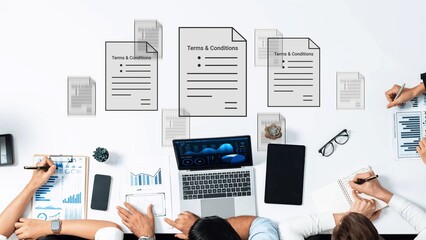 Business meeting with documents on terms and conditions, graphs, and charts showcasing analysis and...