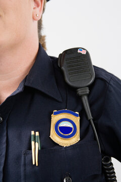 Shield and hand mike on a police officer's shoulder