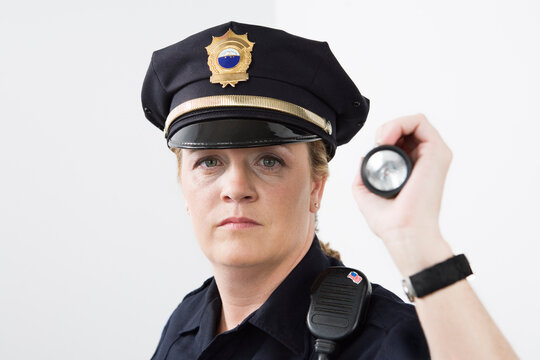 Portrait of a police woman holding a flashlight