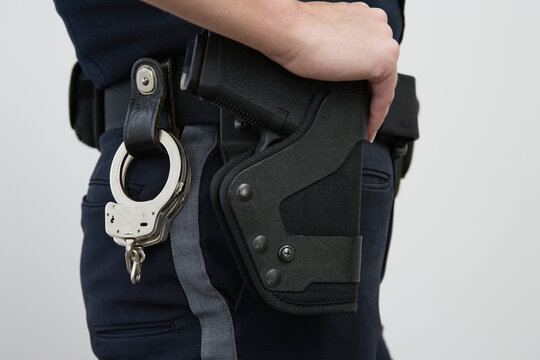 Female police woman with a holstered handgun and hand cuffs