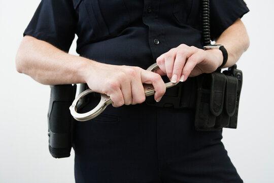 Close up of a police woman holding hand cuffs