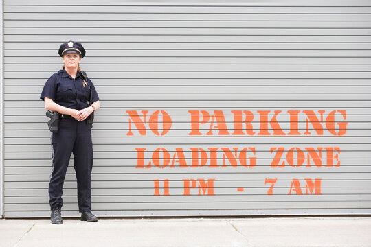 Woman police officer standing in front of a shutter
