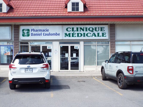 Gatineau, Quebec, Canada &ndash; May 9, 2026: The storefront of the "Pharmacie Daniel Coulombe and a medical clinic" features prominent signage and cars parked in front at 325 Bd Gr&eacute;ber.