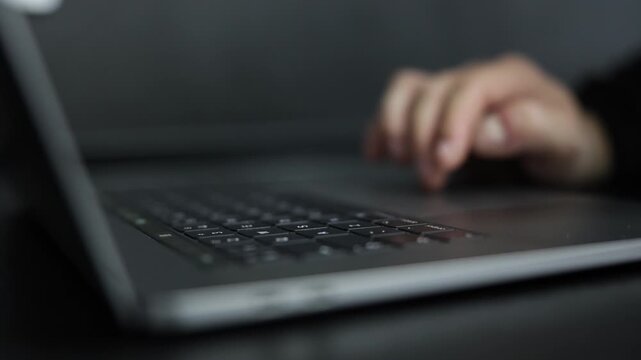 Detailed cinematic close-up of a hand operating a laptop mouse, featuring scrolling and clicking actions that represent digital navigation, productivity, technology, and modern computer use.