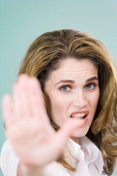 Portrait of a mid adult woman showing a Stop hand gesture