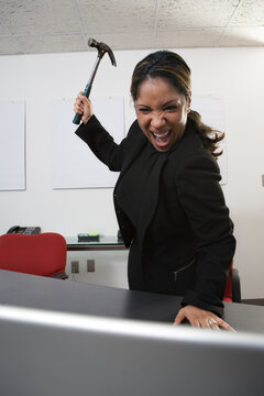 View of a frustrated women holding a hammer