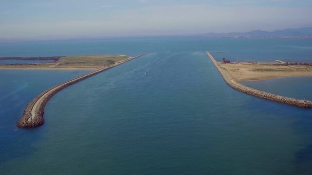 win stone breakwaters carve a calm harbor channel into Morocco's coastal sea.