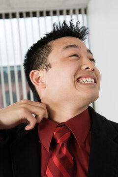 View of a mid adult man adjusting his collar