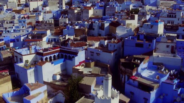 Drone descends and pulls back over Chefchaouen, revealing a white minaret.