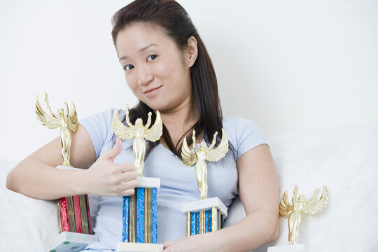 Portrait of a young woman holding trophies