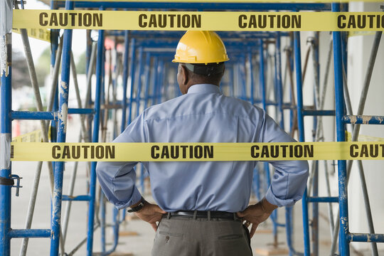 Rear view of a male architect standing at a construction site