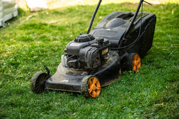 Obraz premium Lawn mower standing on freshly cut garden grass