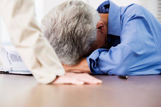 View of a tired business man resting his head on a table