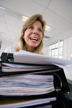 A frustrated business woman in front of files