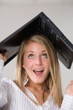 A woman with a laptop over her head