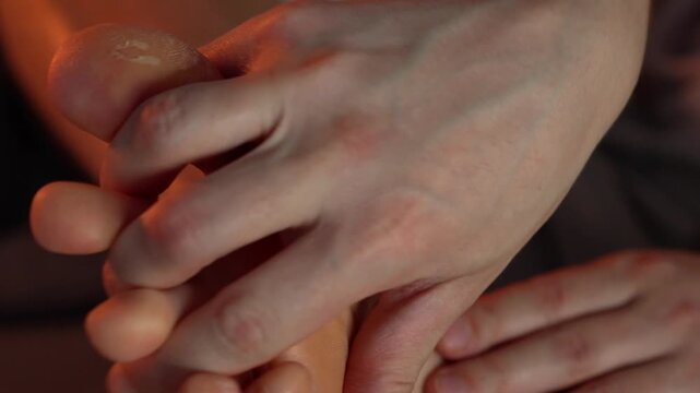 Tired legs.
A man strokes his legs, gives a relaxing massage, and massages his feet with his hands.