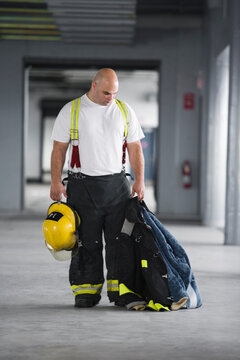 A Fireman holding a jacket and a hardhat
