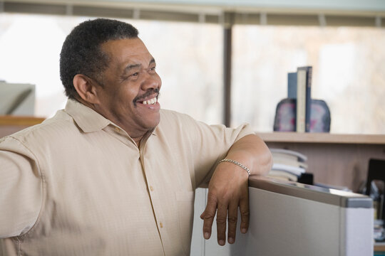 Businessman leaning on a cubicle in an office