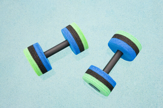 Close-up of two hand weights floating on water