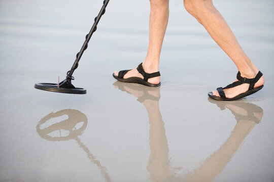 Low section view of a person with metal detector
