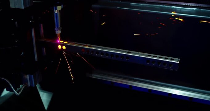Modern CNC laser machine.Cinematic close-up shot  of automated laser cutter processing a on steel. Bright sparks. Industry 4.0 and advanced technology.
