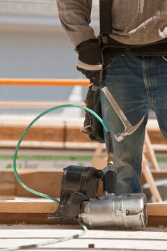 Carpenter and nail gun at a construction site